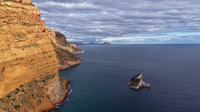 Sunlit Cliff Coastline With Sea Stack, Aerial Inspection Of Rugged Sandstone Outcrop, Calm Blue Sea, Isolated
