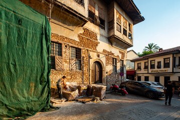 Obraz premium Antalya, Turkey - August 27, 2026: The image shows a historic cobblestone street in Kaleiçi, the old town of Antalya, Türkiye, featuring traditional Ottoman-style architecture and ancient stone. Histo