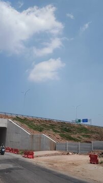 Concrete highway underpass construction site with blue sky and road barriers
