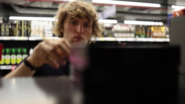 Shopper takes all products on sale from supermarket shelf trying to save money and benefit from special offers while buying discounted groceries during a routine shopping trip