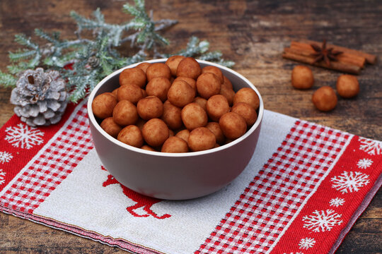 Traditionelle Marzipankartoffeln in einer grauen Schale auf einem weihnachtlichen Tischl&auml;ufer mit Zimt und Sternanis.