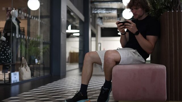 Student plays mobile games on his smartphone instead of studying and developing skills showing digital distraction procrastination screen addiction and wasted free time daily
