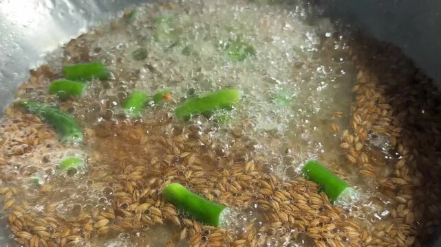 Adding Green Chilies Garlic Cumin Tadka Hot Oil Pan. Vertical video of adding green chilies and garlic to crackling cumin seeds in bubbling hot oil for Indian tempering.