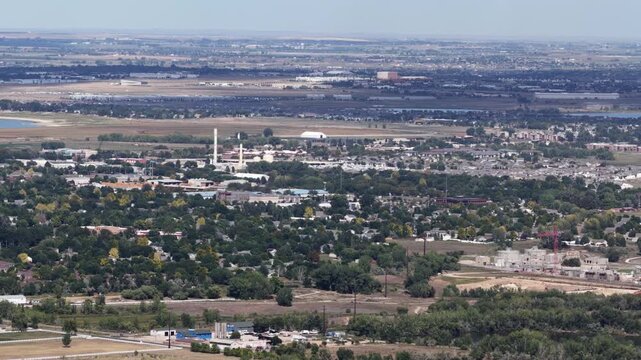 Aerial of suburban and industrial landscape near Campion Colorado with open fields and dense tree cover