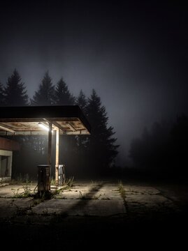Abandoned vintage gas station glowing in midnight fog detail