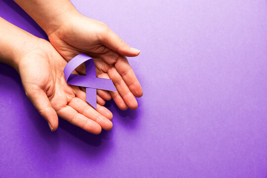 Hands holding purple ribbon promoting awareness and support