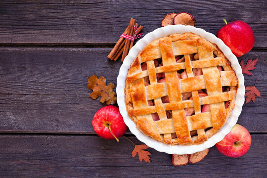 Homemade autumn apple pie. Top down view table scene over a dark wood background. Copy space.
