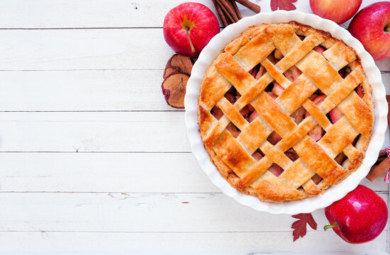 Homemade autumn apple pie. Above view table scene over a white wood background. Copy space.