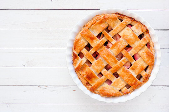 Homemade autumn apple pie. Overhead view on a white wood background.