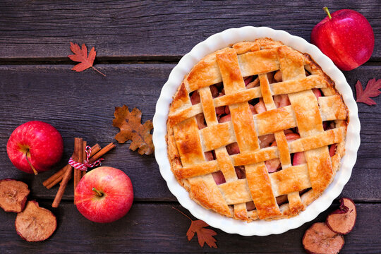 Homemade autumn apple pie. Overhead view table scene on a dark wood background.