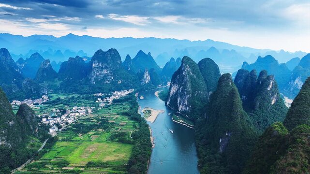 Aerial view of karst mountain peaks along the Li River in Guilin, Guangxi, China, under a cloudy sky during soft daylight.