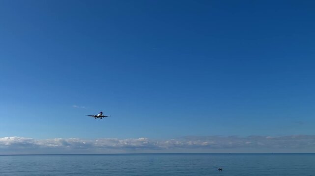 Passenger plane landing, wide view above the Black Sea on approach to Batumi runway, showing airport arrival traffic, tourism access, commercial aviation and regional air transport in Georgia