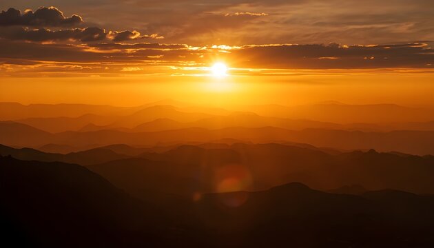 Golden hour sunrise over layered mountain ranges with dramatic sun rays illuminating distant clouds