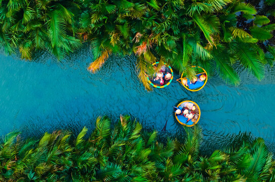 Aerial view of basket boats navigating lush waterways in hoi an, vietnam