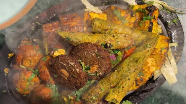 Sizzling Indian Kebab Platter Hot Steam Close Up. Vertical video of steaming hot mixed tandoori platter with seekh kebab, paneer tikka, and sizzler plate presentation.