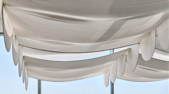 Suspended acoustic baffles forming large continuous fabric canopy with three dimensional undulations made from stretched polyester