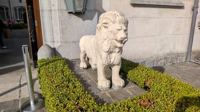 Slow motion close up view of the historic stone lion statue at the main entrance of Palacio Boa Vista governor palace, showing European-style architecture. 