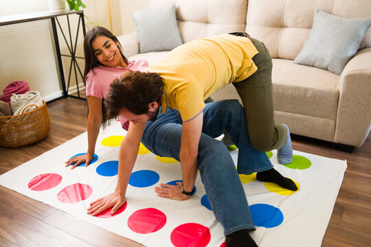 Fun couple enjoying a fun date at home, playing a board game on the floor, laughing and bonding