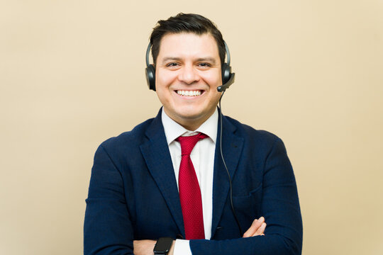 Latin male customer service representative wearing headset and suit, offering professional support and assistance