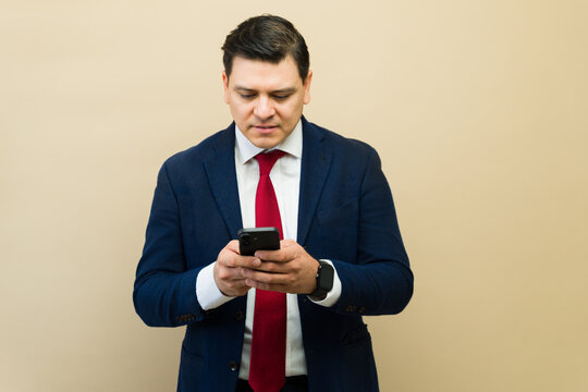 Professional businessman using smartphone for communication and networking, sending text messages