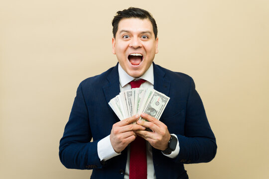 Excited man shouting and celebrating holding us dollar banknotes, representing success, winning, and wealth concept