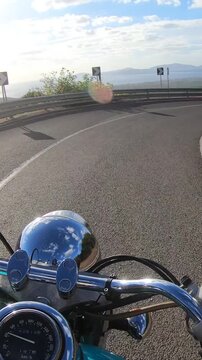 Vertical POV ride on a custom turquoise motorcycle descending a winding rural road, with natural engine and exhaust sounds creating an immersive first person motorcycle travel experience.