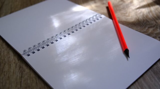Open notebook with a blank page,pencil. Sunlight creates dynamic highlights, shadows across the paper. Creativity, planning, new beginnings, brainstorming.  Education, writing, design-related content.