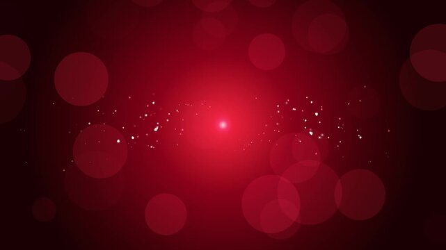 Glowing red bokeh light background with sparkling central particles for romantic celebration
