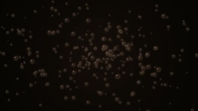 Rising golden bubbles sparkling on dark background for carbonated drinks or beer animation