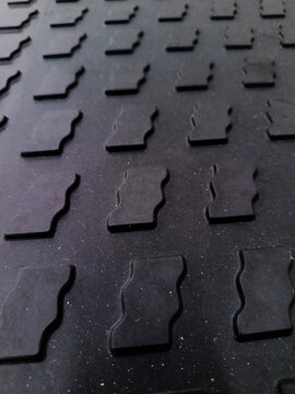 Detailed close-up of black industrial anti-slip rubber mat texture.
