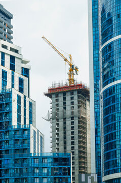Construction site with crane, multi storey buildings, hotels. Construction site on a sunny bright day against the sky. Construction of buildings in the city of Batumi, Georgia