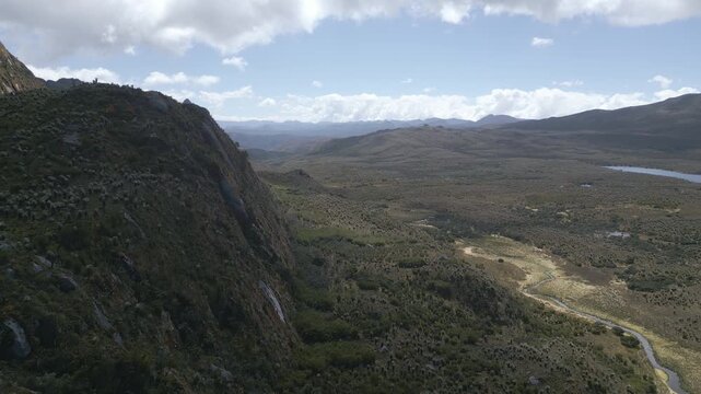 Aerial drone view of the high-altitude Sumapaz Paramo ecosystem in Colombia featuring native frailejon plants, glacial lakes, and rugged Andean mountains.