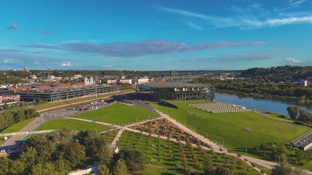 Aerial drone view of Zalgirio Arena on Nemunas Island in Kaunas, Lithuania, showcasing the modern sports and entertainment venue surrounded by the Nemunas River. 4K video footage
