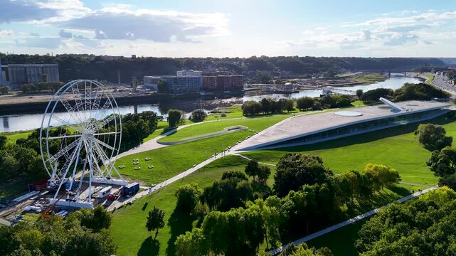 Aerial drone view of Science Island Museum and Ferris wheel on Nemunas Island in Kaunas, Lithuania, showcasing modern architecture and a new city attraction