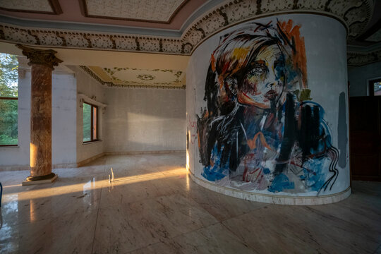 Abandoned luxury mansion interior with marble hall, ornate fireplace, swimming pool and glass facade
