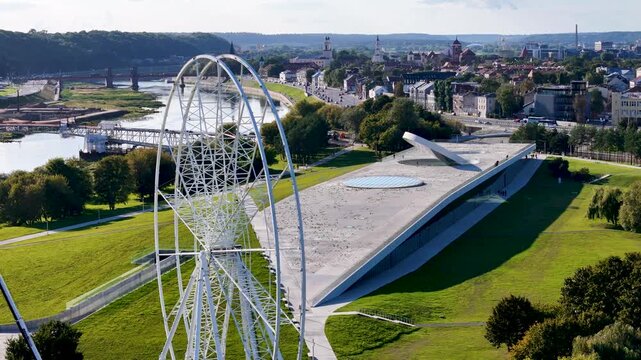 Aerial drone view of Science Island Museum and Ferris wheel on Nemunas Island in Kaunas, Lithuania, showcasing modern architecture and a new city attraction