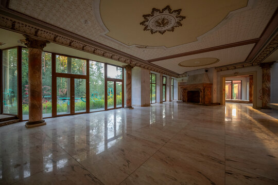 Abandoned luxury mansion interior with marble hall, ornate fireplace, swimming pool and glass facade