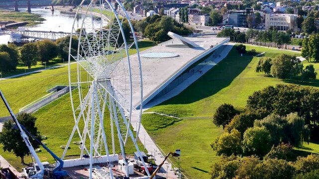 Aerial drone footage of a Ferris wheel under construction on Nemunas Island in Kaunas, Lithuania, showing a new observation attraction rising in the city center. 4K video 