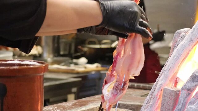 Seasoning Fish Skewers with Salt Before Grilling on Robatayaki Charcoal Pit