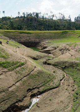 ORLIK RESERVOIR, CZECH REPUBLIC - AUGUST 7, 2026: Extremely low water levels at Orlik Dam, cracked muddy ground, green algae, and an old historic stone bridge normally submerged underwater.