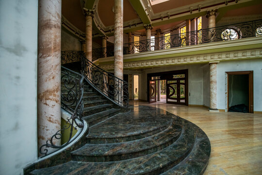 Abandoned luxury mansion interior with marble hall, ornate fireplace, swimming pool and glass facade