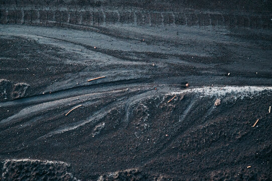 Abstract Black Volcanic Sand Texture with Natural Flow Patterns