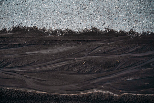 Abstract Black Volcanic Sand Texture with Natural Flow Patterns