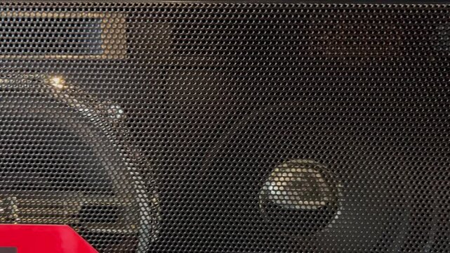 Close up panning shot of speaker protective metal mesh grill