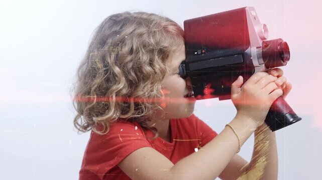 small girl looks with vintage film camera