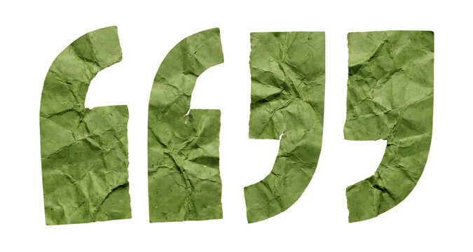 Quotation marks cut from textured green handmade paper on a black background