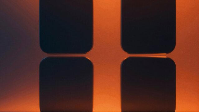close four square shaped objects arranged diagonal line objects black color appear glossy material background gradient orange purple orange being dominant color orange side while purple middle black
