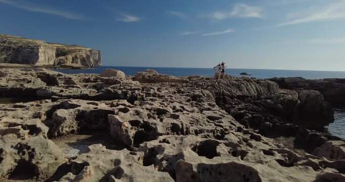 Low Angle Pan Across Rocky Coast with Dwejra Tower and Sea View, Gozo, Malta