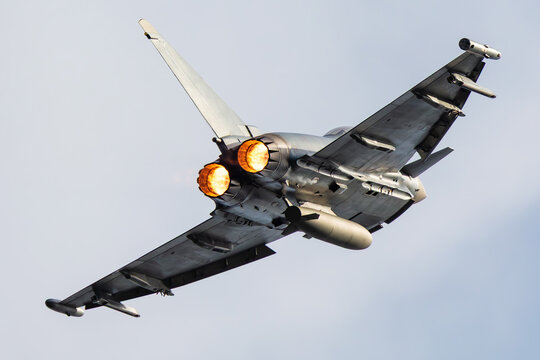 Twin engine fighter jet banking with afterburners