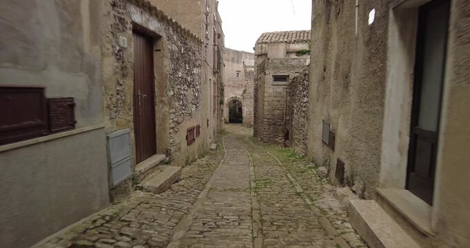Forward Tracking Shot Down Narrow Cobblestone Alley Towards Wrought Iron Gate, Erice, Italy